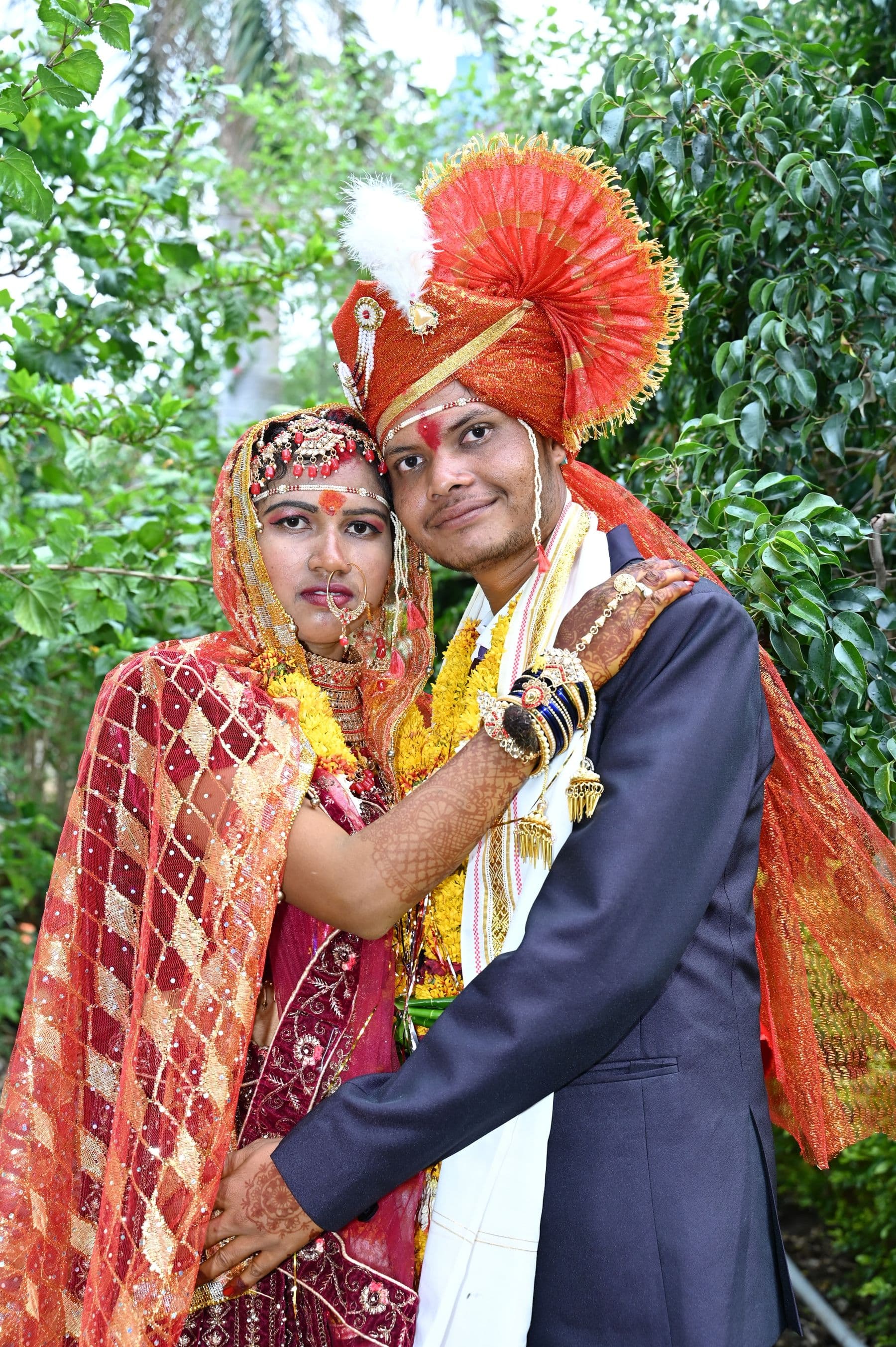 A couple in red and gold wedding dress, laughing together
